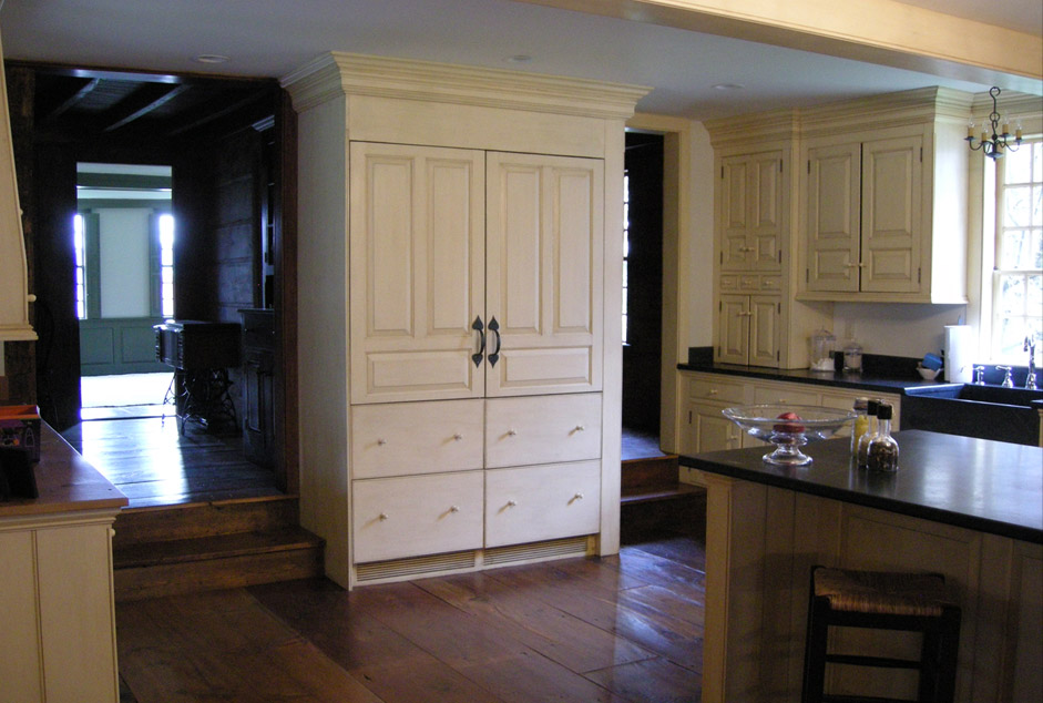 Cream pantry armoire with drawers, installed in period kitchen