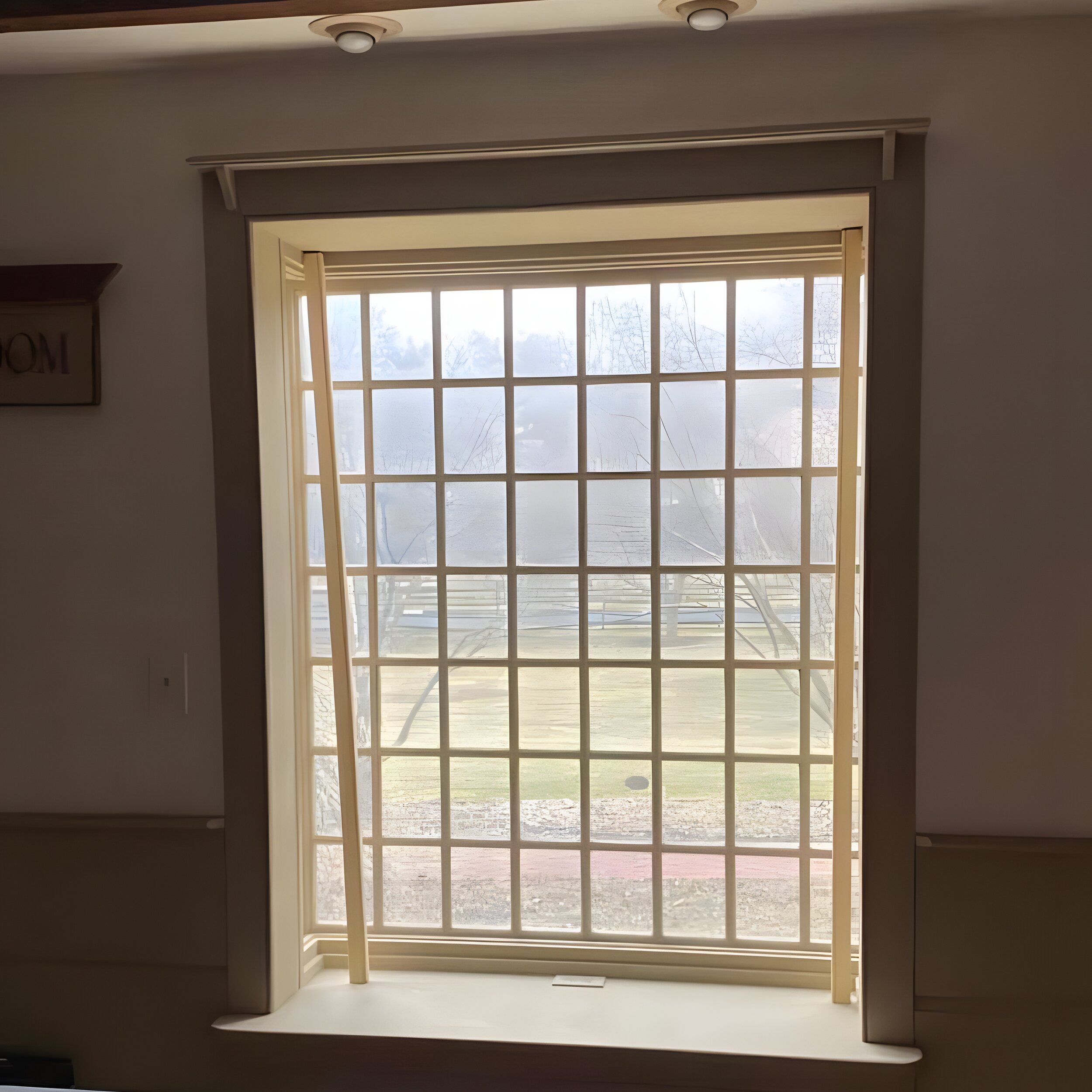 BEFORE — bare window with grid glazing bars, no shutters installed