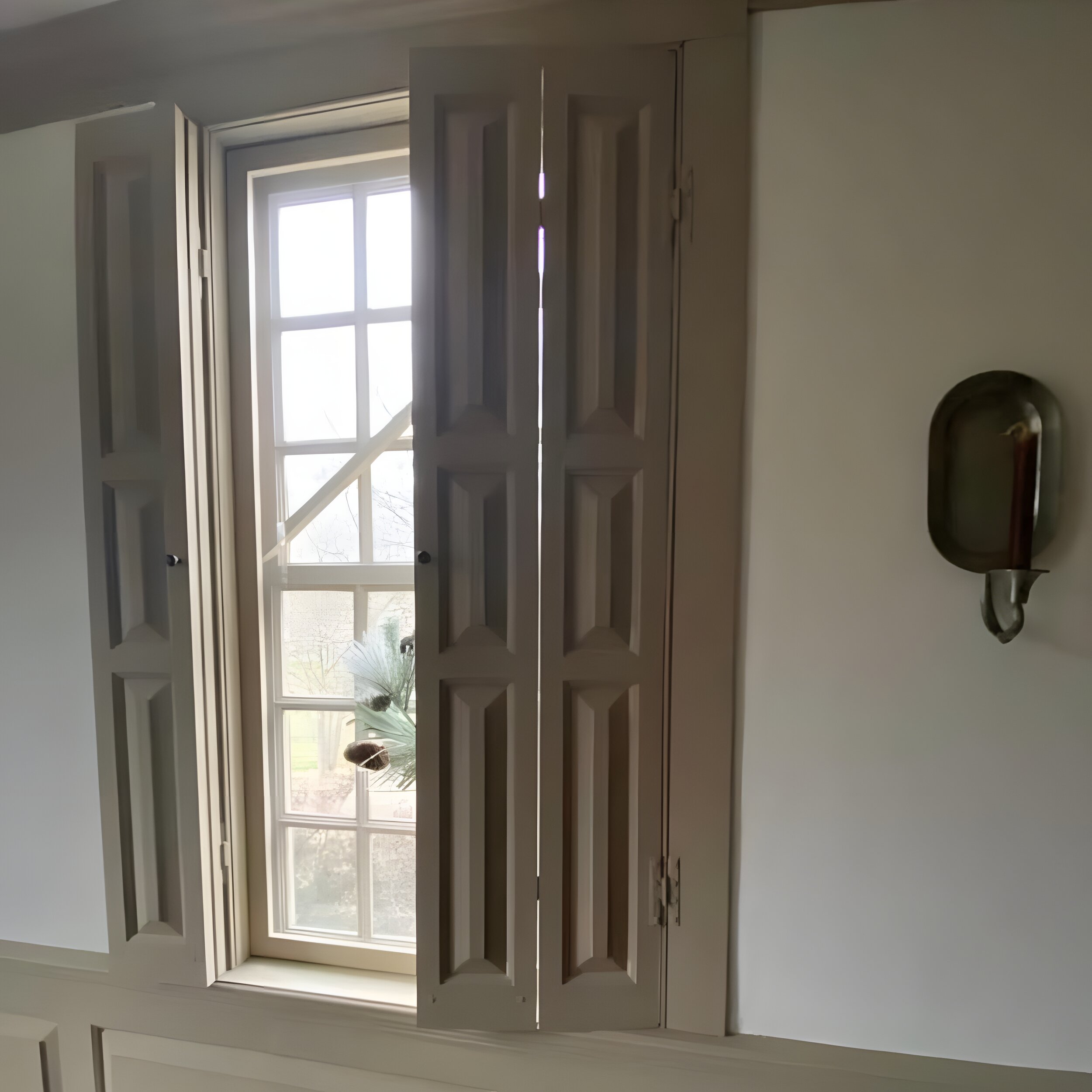 BEFORE — bare large grid-glazed window, taupe trim, no shutters